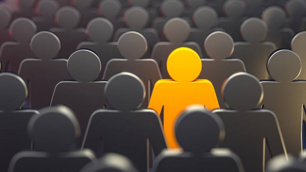 Crowd of silhouettes with one person in bright orange